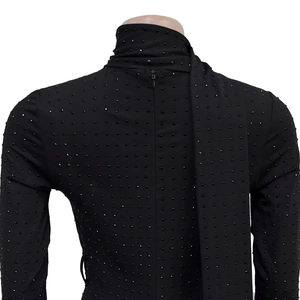 Detail of black V-neck jumpsuit with studs, back view featuring invisible zipper and sash