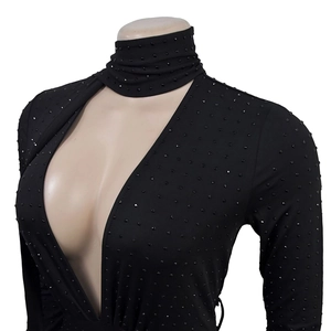 Detail of black long sleeve bodysuit featuring a deep V-cut and sparkly rhinestones