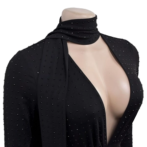 Detail of black long sleeve deep V-neck jumpsuit featuring silver rhinestones and choker