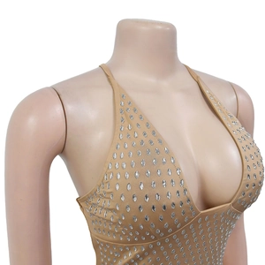 Détail d'une robe moulante chair avec strass argentés brillants et décolleté plongeant