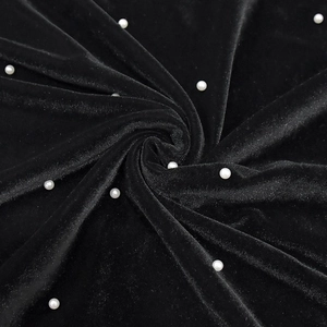 Détail macro du tissu en velours noir avec perles blanches en motif de spirale