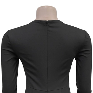 Detail view of the seamless back invisible zipper on a black long sleeve jumpsuit