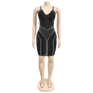 Détail de la robe moulante noire avec strass argentés et décolleté en mesh transparent