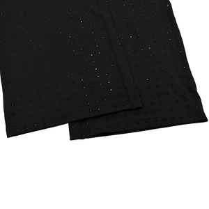 Detailed macro view of black fabric with neatly arranged rhinestones on a long sleeve jumpsuit