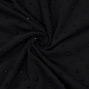 Detail of black V-neck jumpsuit fabric with shimmering rhinestones and soft pleats