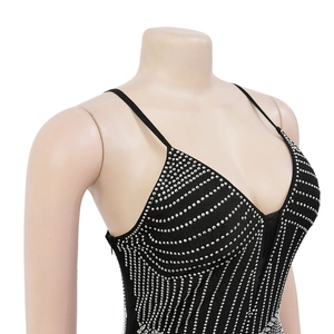 Détail d'une robe de soirée noire avec strass argentés brillants et bretelles fines