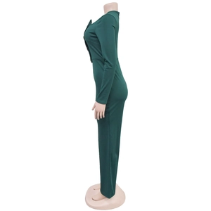 Detail of dark green jumpsuit with V-neckline, long sleeves and gold decorative buttons