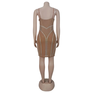 Gros plan d'une mini robe moulante caramel ornée de motifs complexes en strass argentés