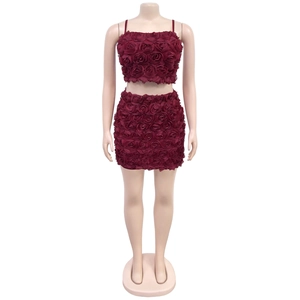 Dettaglio del completo a due pezzi bordeaux con trama di petali di rosa 3D e crop top