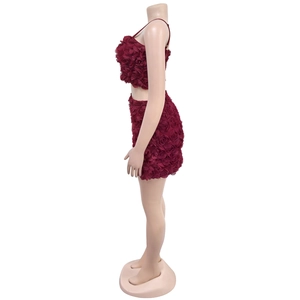 Dettaglio ravvicinato della texture con rose 3D bordeaux sul set due pezzi top e gonna corta