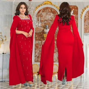 Detail of red elegant evening gown with rhinestone neckline and flowing cape sleeves
