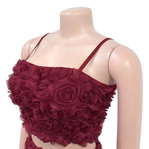 Dettaglio delle decorazioni con rose 3D in tulle su un top a fascia rosso vino