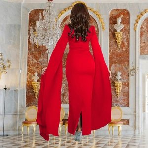 Detailed back view of red evening gown with dramatic floor-length cape sleeves and backless cut