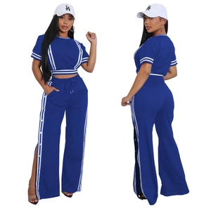Dettaglio di un completo blu navy a due pezzi con strisce laterali e bottoni a scatto