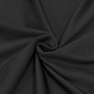 Close-up of black high-density knit fabric texture with elegant pleated drape details