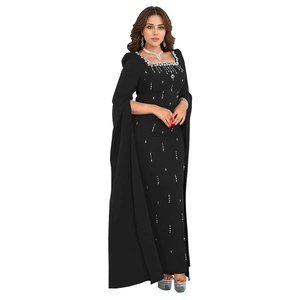 Close-up of elegant black dress featuring cape sleeves and sparkling rhinestone neckline