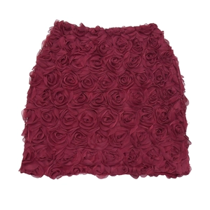 Dettaglio della trama rosa 3D su completo due pezzi con top a fascia e gonna bordeaux