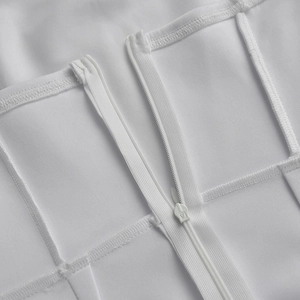 Close-up of invisible zipper and seam detail on white off-shoulder bodycon dress