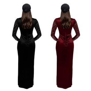 Dettaglio del vestito lungo in velluto con eleganti perline sulle maniche lunghe