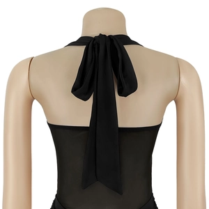 Detail view of black halter top featuring sheer mesh fabric and back bow-tie closure