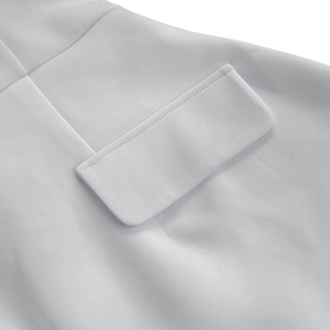 Detailed close-up of white woven fabric with a flap pocket and precision stitching