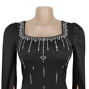 Close-up of square neck black dress with sparkling rhinestones and split cape sleeves