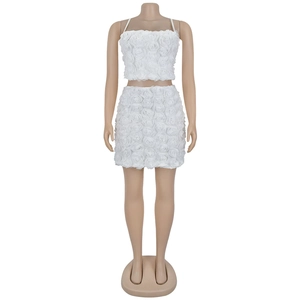 Dettaglio della texture floreale 3D bianca su un completo crop top e minigonna