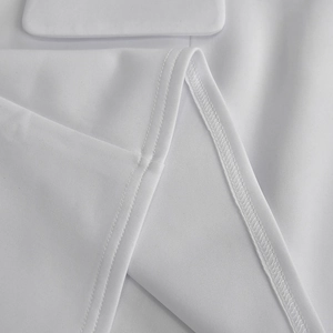 Close-up of white off-the-shoulder dress showing clean double-needle stitching and fabric