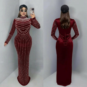 Dettaglio dell'abito lungo in velluto bordeaux con eleganti perle e collo alto