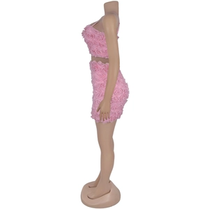 Dettaglio di un set rosa a due pezzi con trama a rose 3D e minigonna a tubino corta