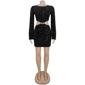 Détail de robe courte noire à paillettes avec découpes à la taille et boucle dorée