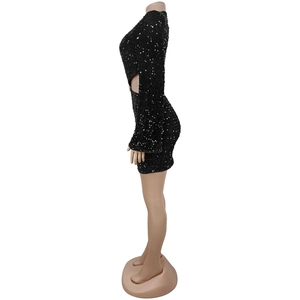 Détail de la mini robe noire à paillettes avec découpe latérale et manches longues