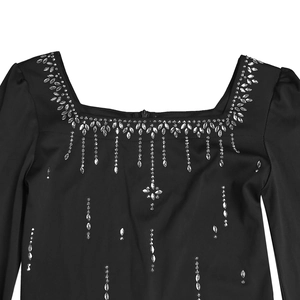 Close-up of black square neck dress featuring elegant rhinestone tassel decorations