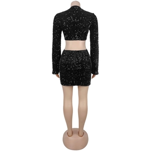 Détail d'un ensemble deux pièces noir à paillettes avec haut court et mini jupe moulante