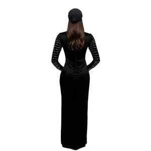 Dettaglio dell'elegante abito lungo in velluto nero con maniche in strass e vestibilità aderente