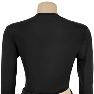 Detail view of the open back cutout on a black long-sleeved dress with premium fabric