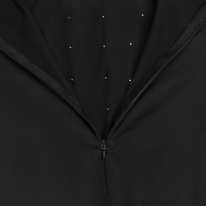 Détail d'une robe noire élégante avec matrice de strass et fermeture éclair invisible