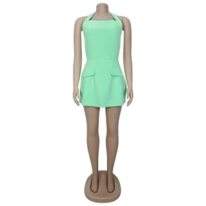 Detail view of mint green halter neck mini dress with side pocket flaps on mannequin