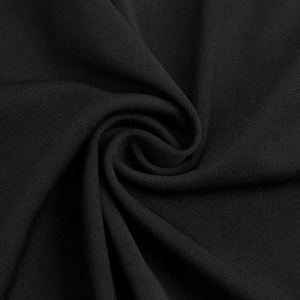 Dettaglio della texture del tessuto in maglia nera con eleganti pieghe drappeggiate