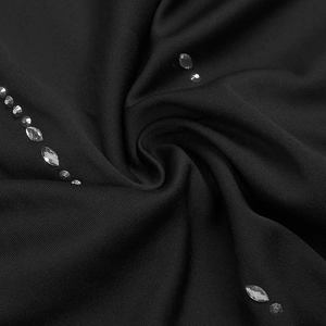 Macro view of black textile dress fabric with silver rhinestone embellishments