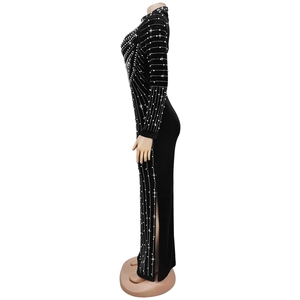 Dettaglio di un elegante abito in velluto nero con strass e spacco laterale alto