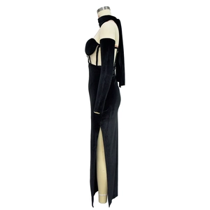 Détail d'une robe en velours noir présentant une fente haute latérale et coupe ajustée