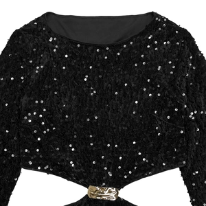 Détail du tissu en velours à paillettes noires avec une boucle décorative en métal doré