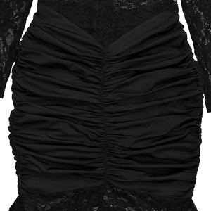 Close-up detail of black ruched fabric with intricate floral lace trim on the dress