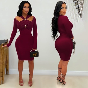Détail d'une robe bordeaux avec décolleté ajouré et boucle métallique décorative