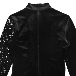 Détail d'une robe en velours noir avec perles et strass élégants sur la manche
