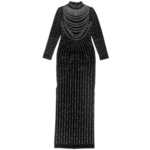 Dettaglio di abito lungo in velluto nero con eleganti perle bianche applicate sullo scollo