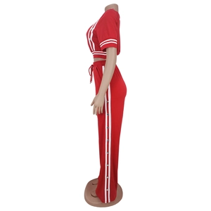 Vista laterale del completo rosso due pezzi con strisce bianche e pantaloni larghi a bottoni