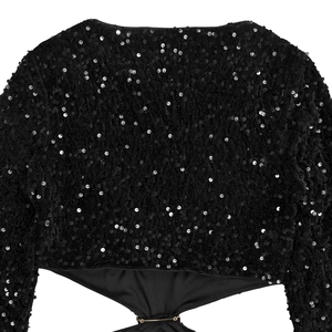 Détail de la robe en velours noir à paillettes avec découpe à la taille et anneaux dorés
