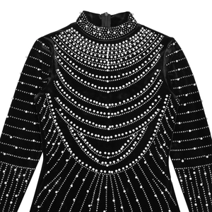 Dettaglio del vestito di velluto nero con eleganti perle e motivi di strass sul corpetto